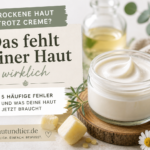 Trockene Haut trotz Creme? Das machst du falsch Beitragsbild mit natürlicher Pflegecreme im Glastiegel, Bienenwachs, Öl und Kamillenblüten zum Thema trockene Haut trotz Creme und häufige Pflegefehler.
